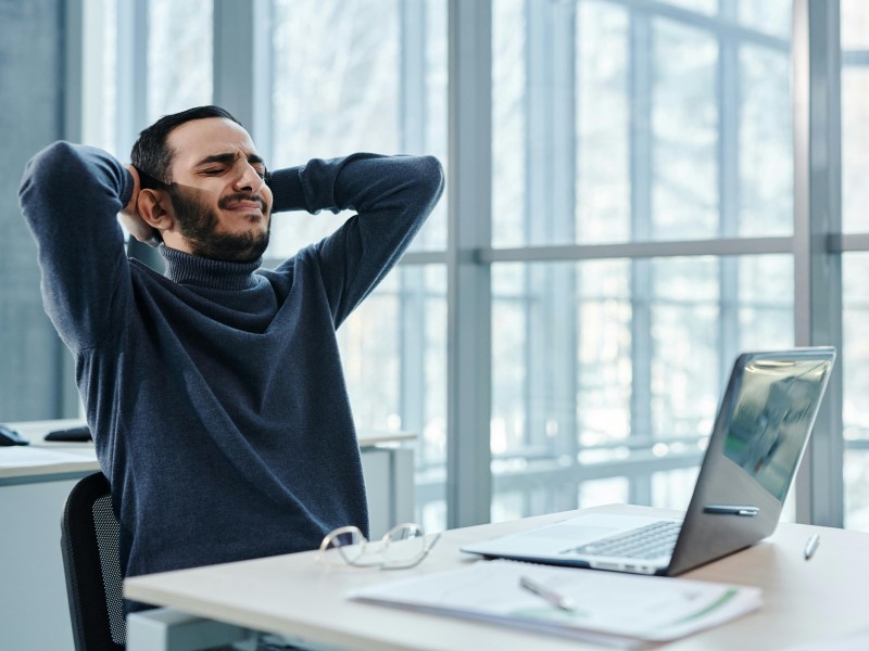 Man die last heeft van rug door zitten achter computer