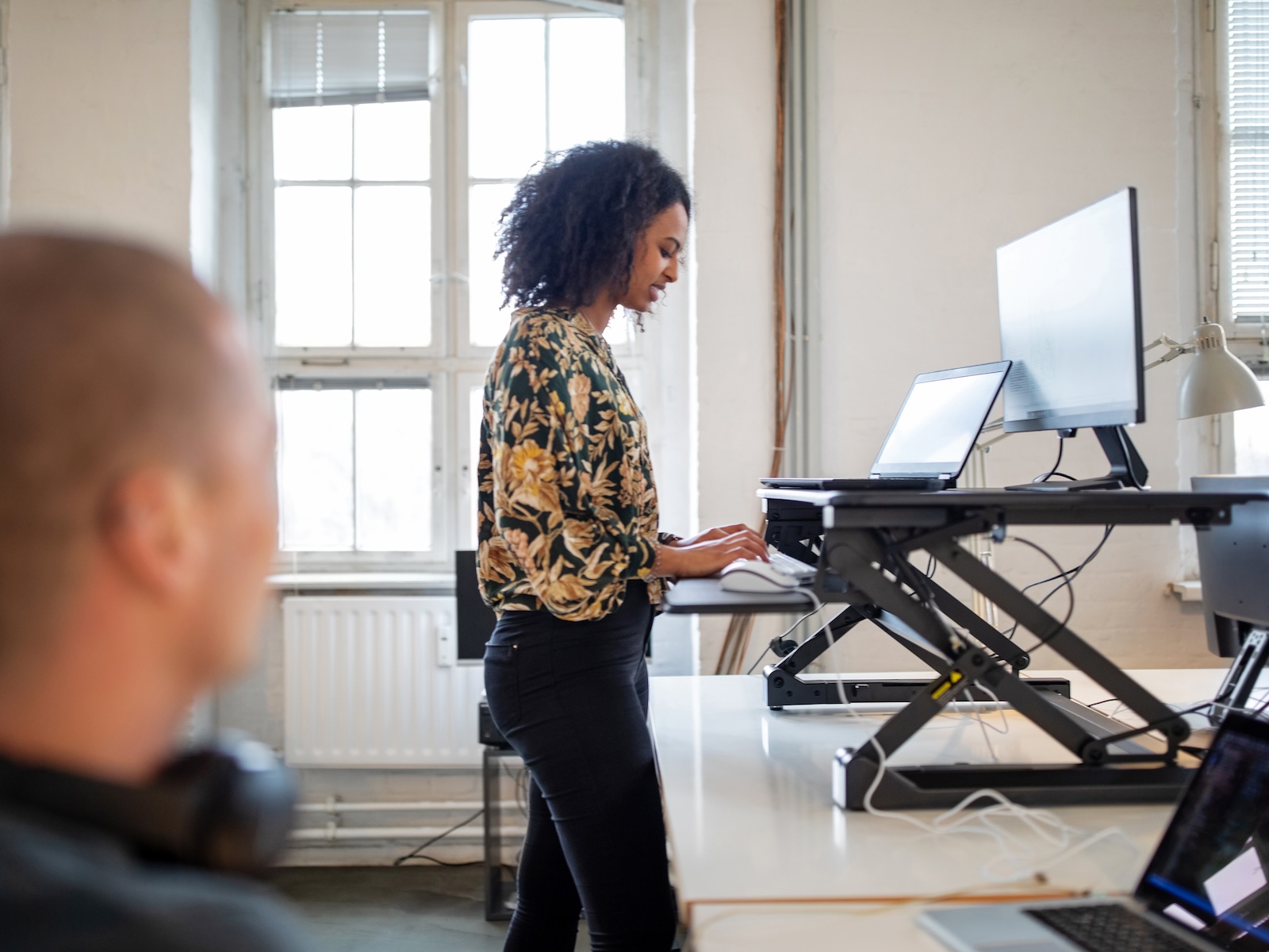 Vrouw achter een zit-sta bureau